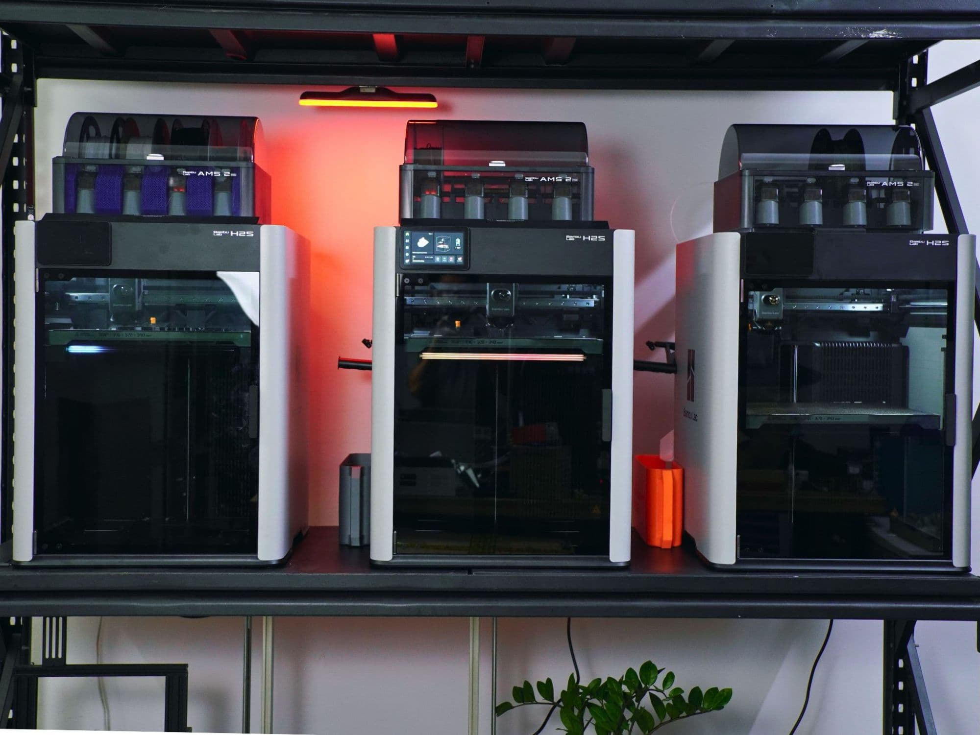 Three Bambu Lab H2S 3D printers, front view